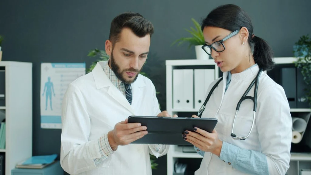 Two doctors reviewing a tablet together